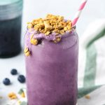 Smoothie in a cup with a straw and granola