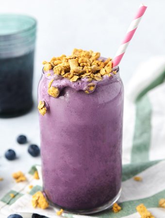 Smoothie in a cup with a straw and granola