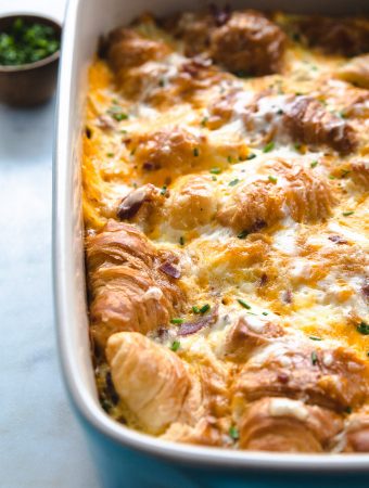 a breakfast strata with croissants in a blue dish.