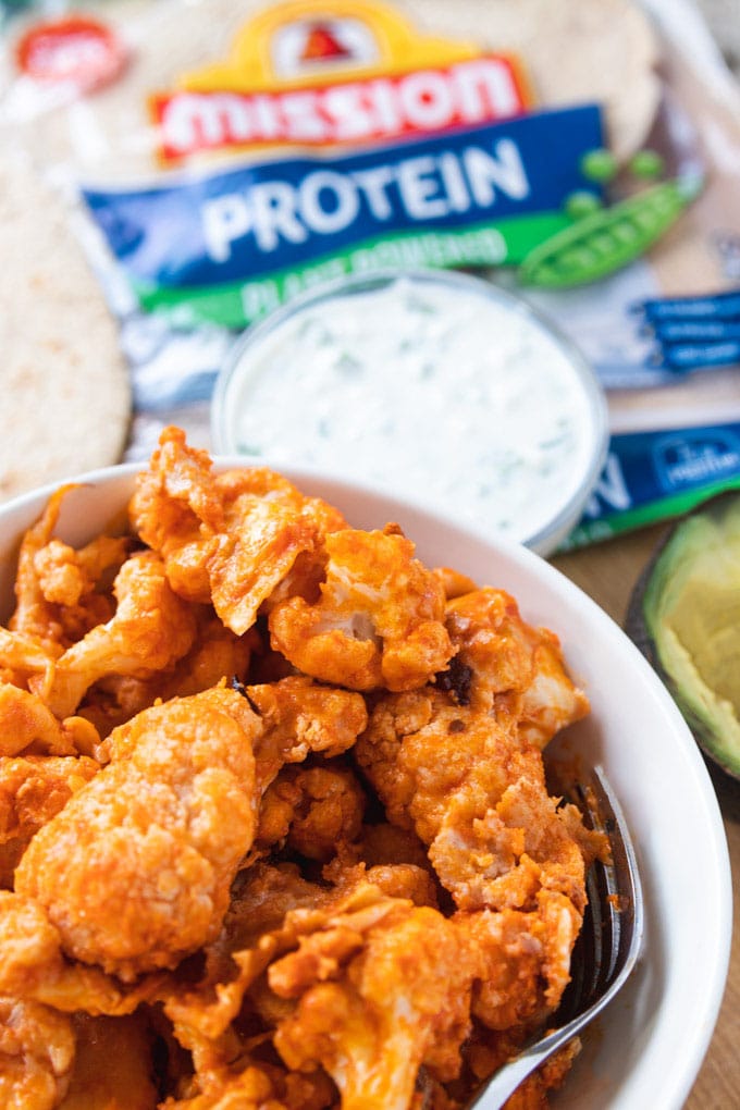 buffalo cauliflower wings in a bowl with sauce. 