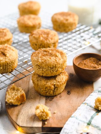 A stack of muffins with crumbs around it.