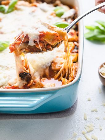 a scoop of chicken pasta bake being pulled out of a casserole dish.