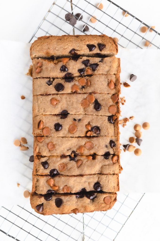 A loaf of bread sliced with chocolate and peanut butter chips on top.