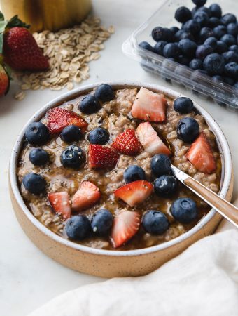 Bowl of instant pot oatmeal with berries on top and a spoon.