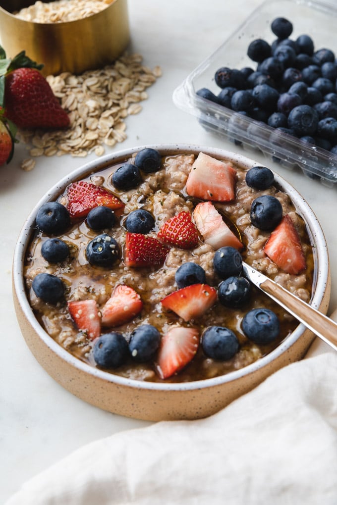 oatmeal with berries and strawberries with a spoon.