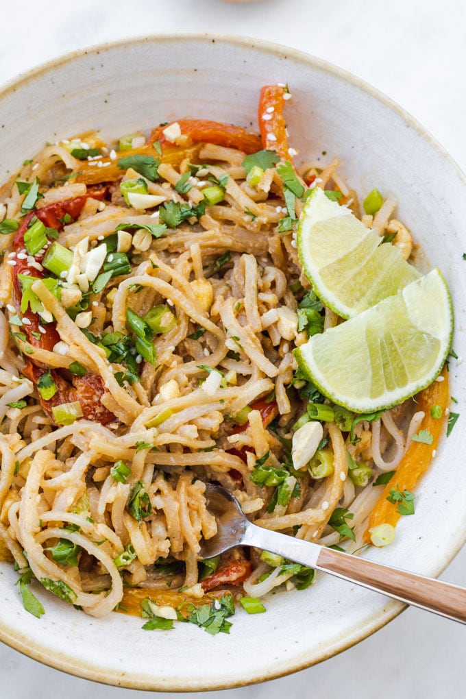 A bowl of noodles with a sliced lime.