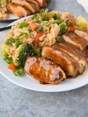Sauce on chicken with rice and vegetables.