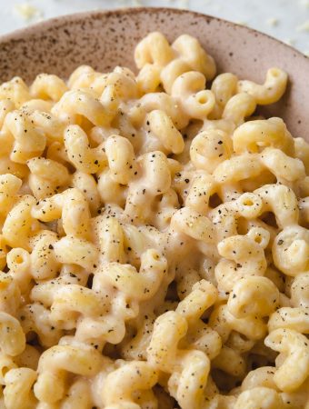 close up of cheesy noodles and black pepper