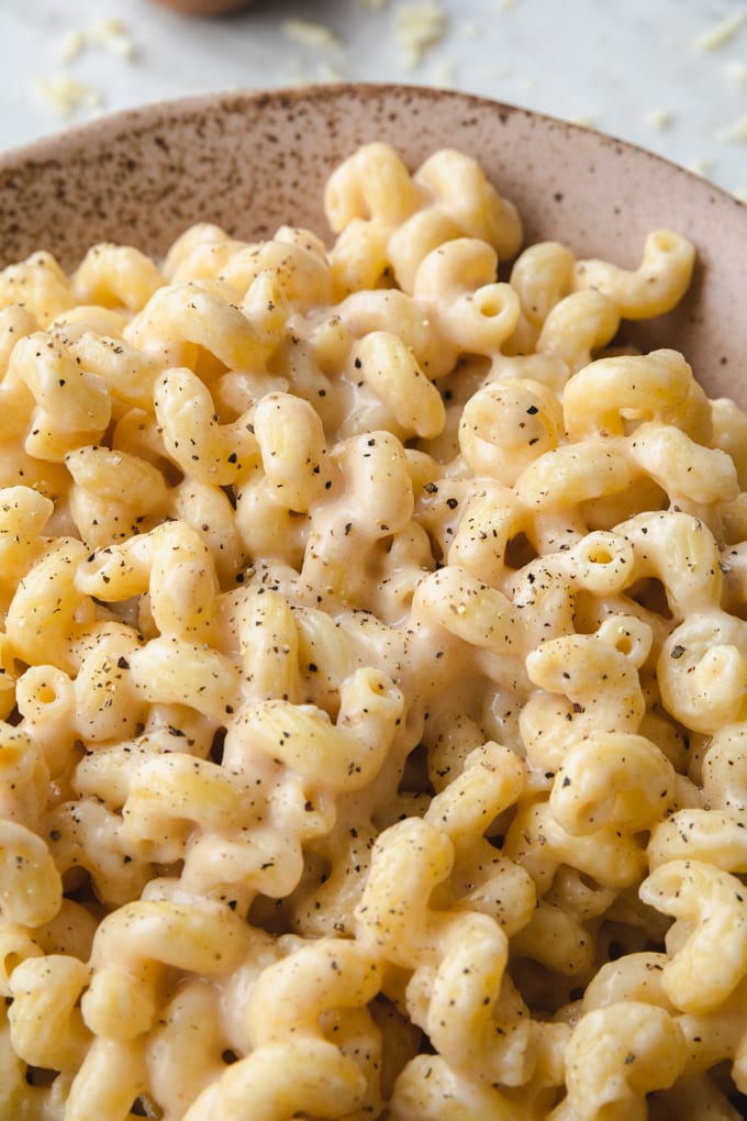 Noodles with cheese and pepper on them in a bowl.