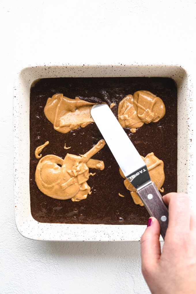 brownie batter with peanut butter and a spatula.