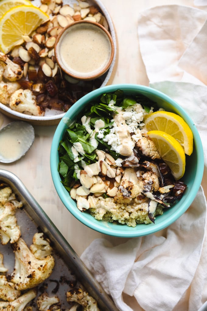 a small bowl of salad with lemons on top and lemon tahini dressing.