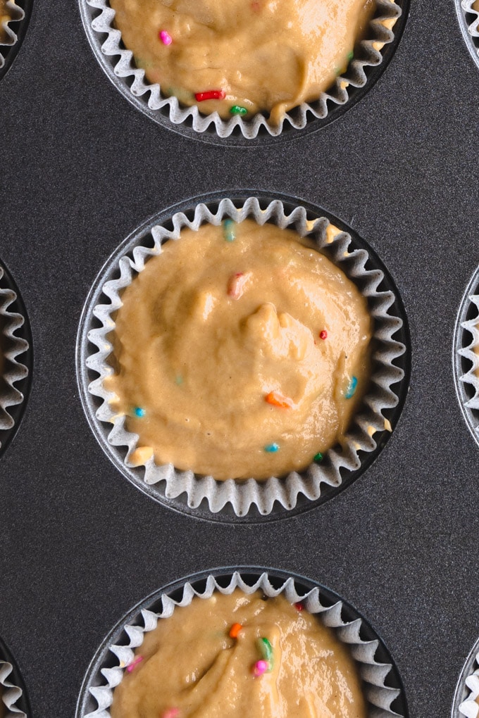 Batter in a muffin tin with sprinkles