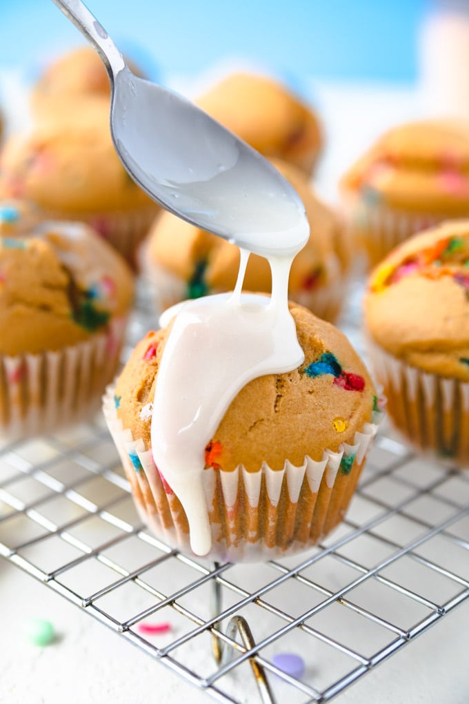 Funfetti cupcakes on a dry rack with a frosting.