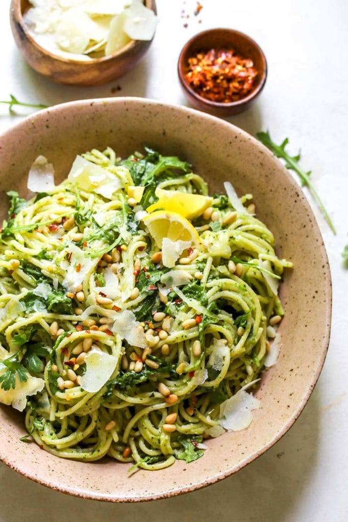 Pesto pea pasta in a bowl with parmesan.