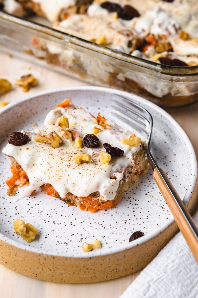 Healthy carrot cake bread pudding on a plate with a fork. 