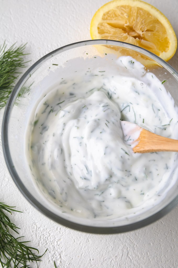 Yogurt tzatziki sauce in a bowl with a spoon.