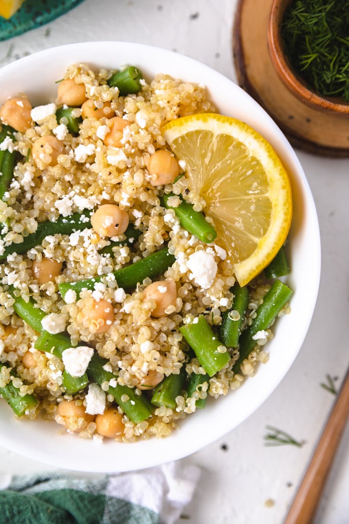 A bowl of green bean quinoa salad with feta and lemon. 