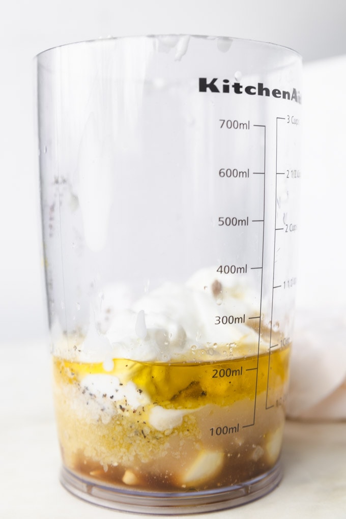 an immersion blender with ingredients for yogurt caesar dressing. 