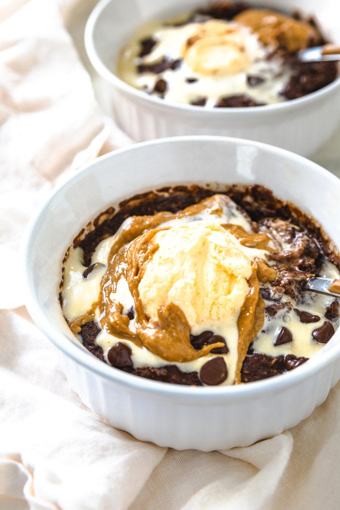 two bowls full of ice cream with toppings and brownie.