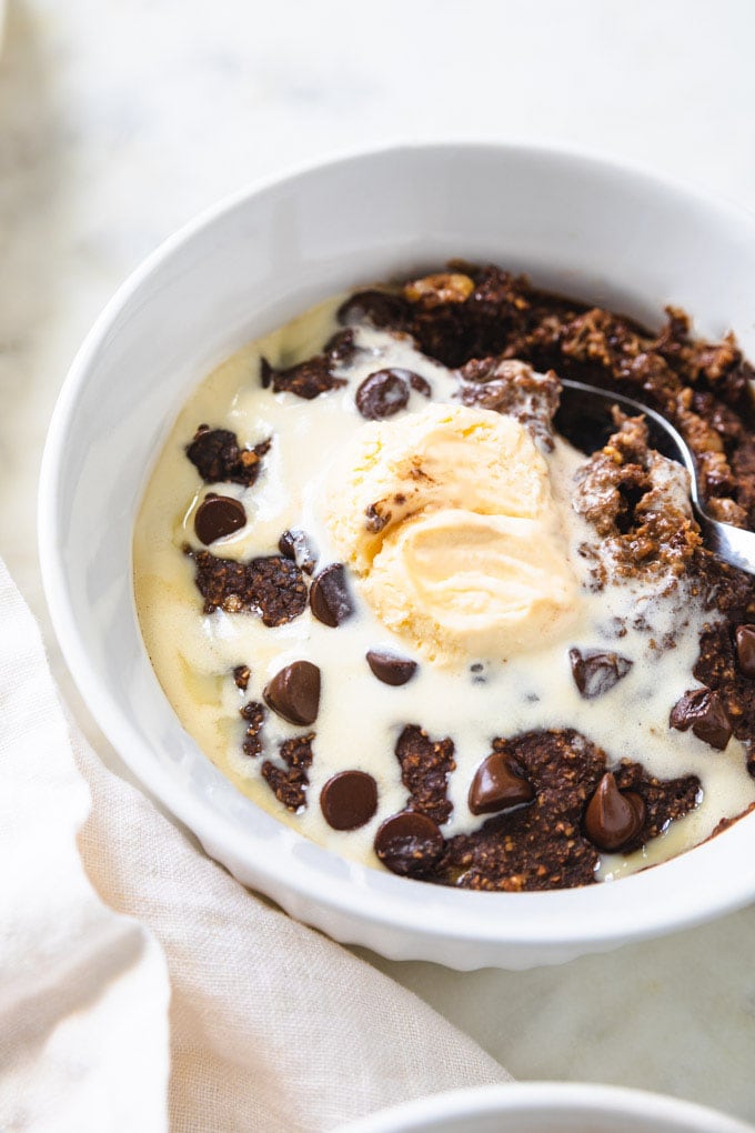 edible brownie batter bowl with a spoon in it and melted chocolate.