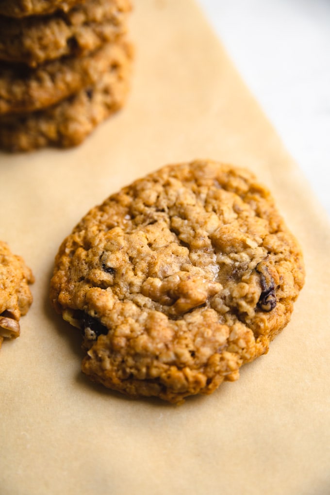 a cookie on parchment paper with raisins and walnuts. 