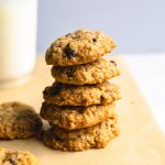 a stack of oatmeal cookies with a glass of milk.