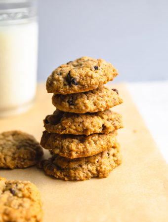 a stack of oatmeal cookies with a glass of milk.