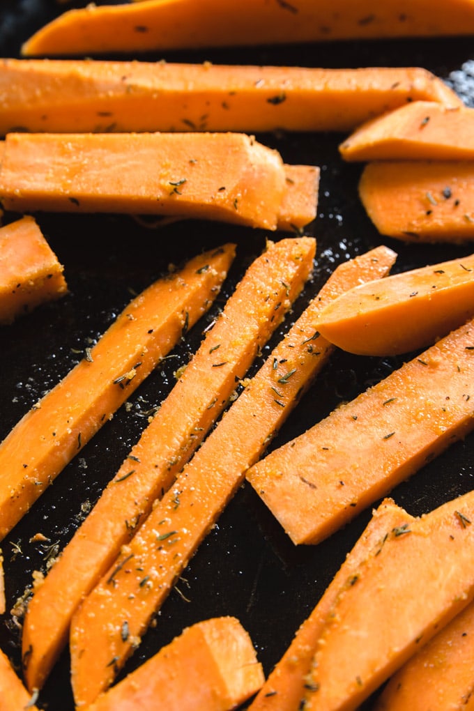Uncooked raw sweet potatoes with seasoning on them. 