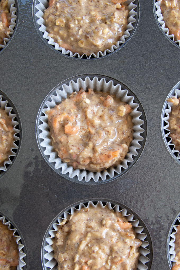 Muffin liners filled with breakfast muffin batter. 