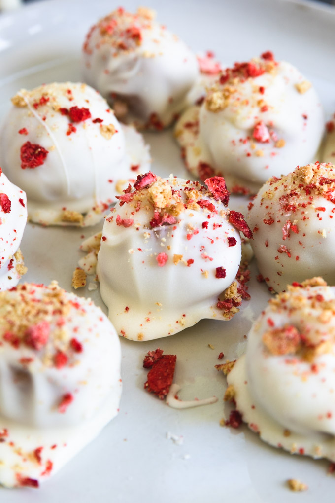 shortcake balls with graham cracker and crushed strawberries on top.