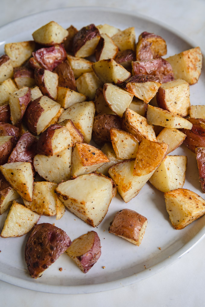 unseasoned roasted red skin potatoes on a plate.