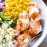 shrimp in a bowl with other vegetables and avocado.