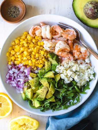 ingredients for salad in a bowl divided with a fork.