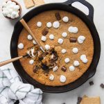 cast iron skillet with marshmallows and chocolate around it.