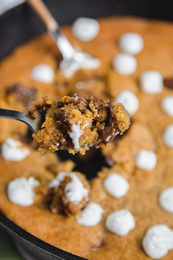 A spoonful of s'mores cookie with melted chocolate and marshmallows. 