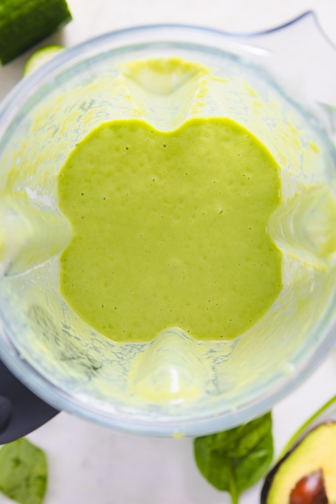The superfood smoothie inside a blender with bubbles. 
