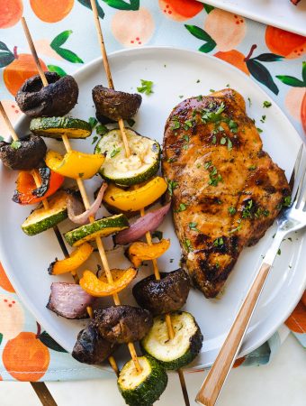 Vegetable kabobs on a plate with grilled chicken