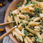 chicken caesar pasta salad in a bowl with forks.