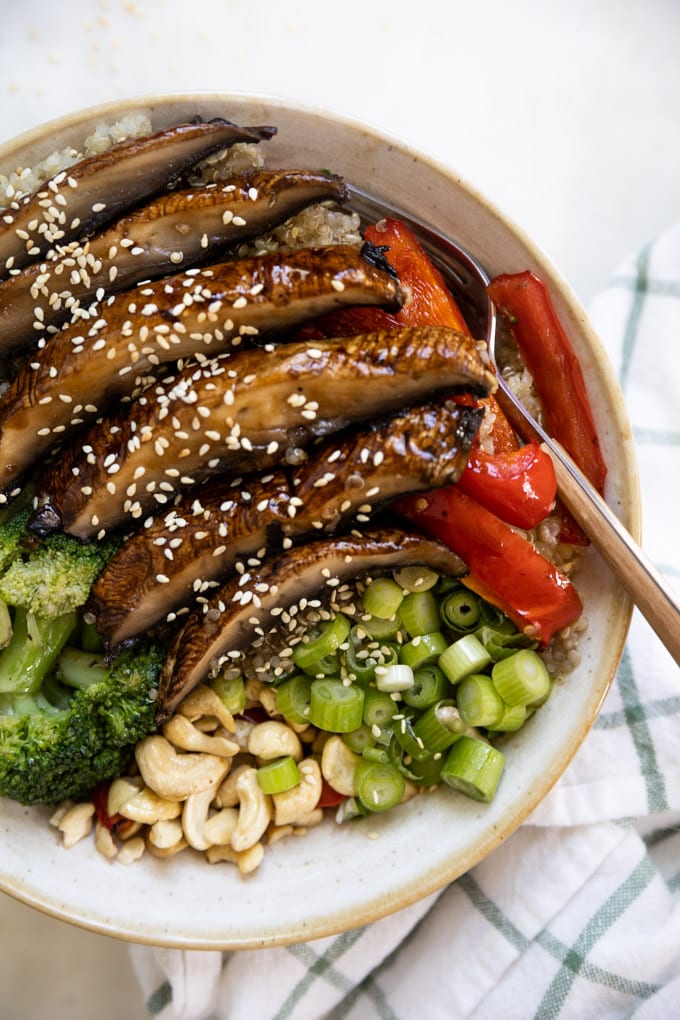 A bowl of asian portobello mushroom stir fry with a fork.