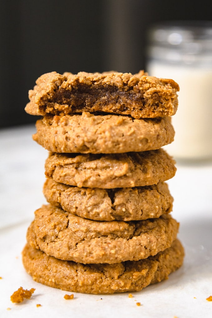 a stack of peanut butter cookies with a mason jar of milk.