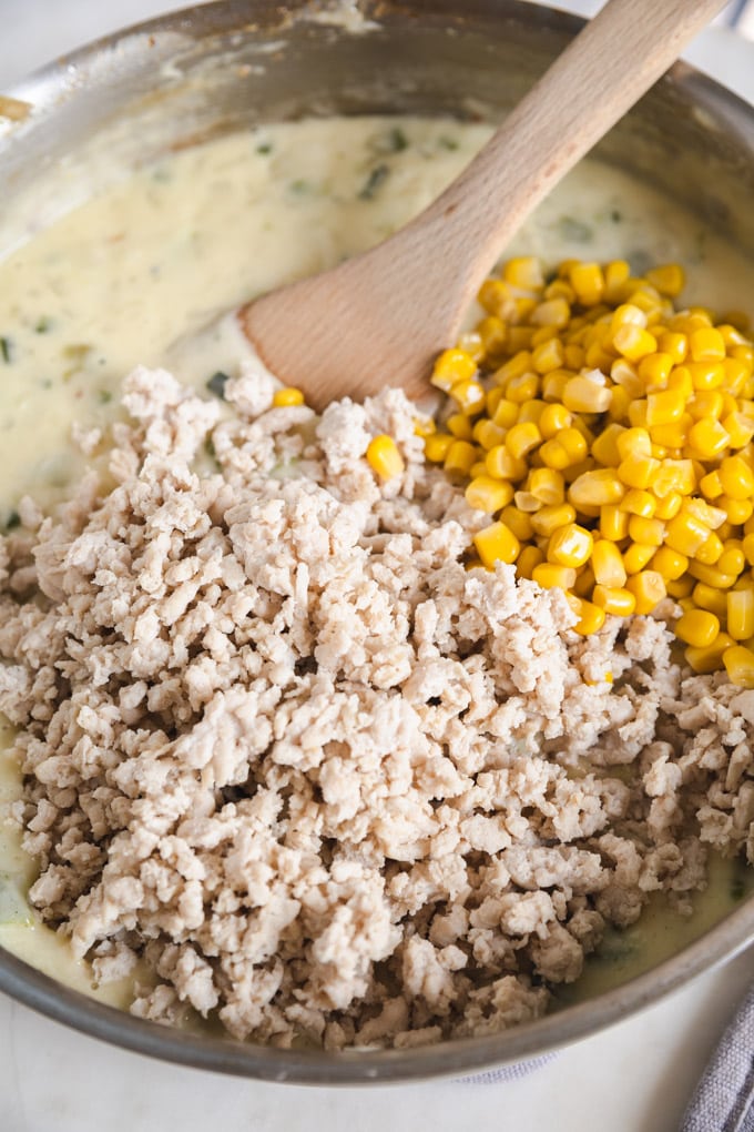 ground turkey and corn on top of cheese in a skillet.