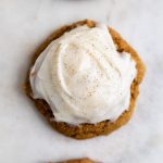 pumpkin cookies in a row with frosting.