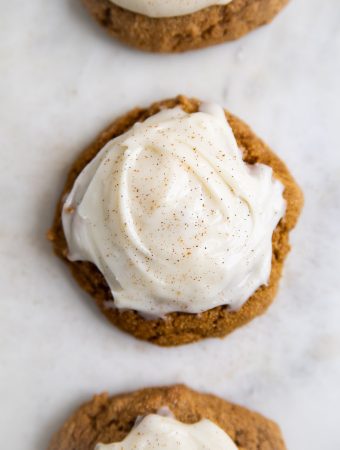 pumpkin cookies in a row with frosting.