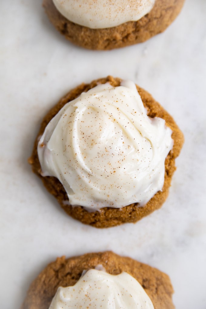 pumpkin cookies in a row with frosting.