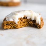 a cookie with a bite taken out of it and frosting on top.