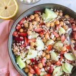 Farro salad with strawberries and cucumbers in a bowl with a spoon.