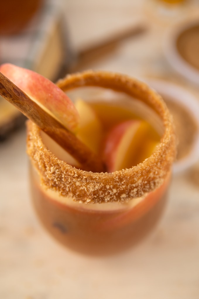 a close up of cinnamon sugar, apples and a cinnamon stick. 