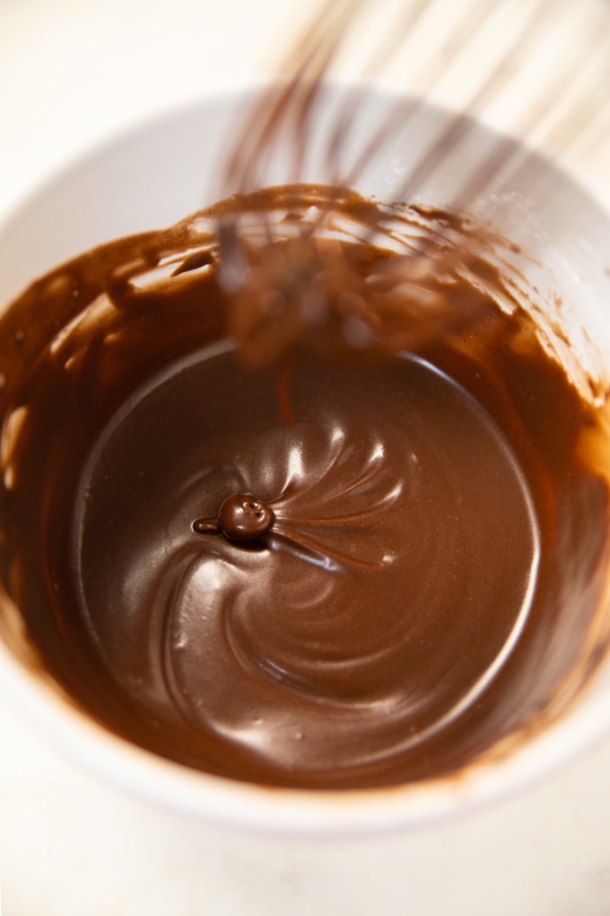 chocolate frosting in a bowl with a whisk. 