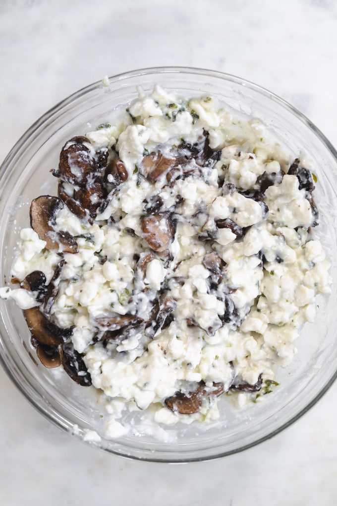 cottage cheese in a bowl with mushrooms and basil.