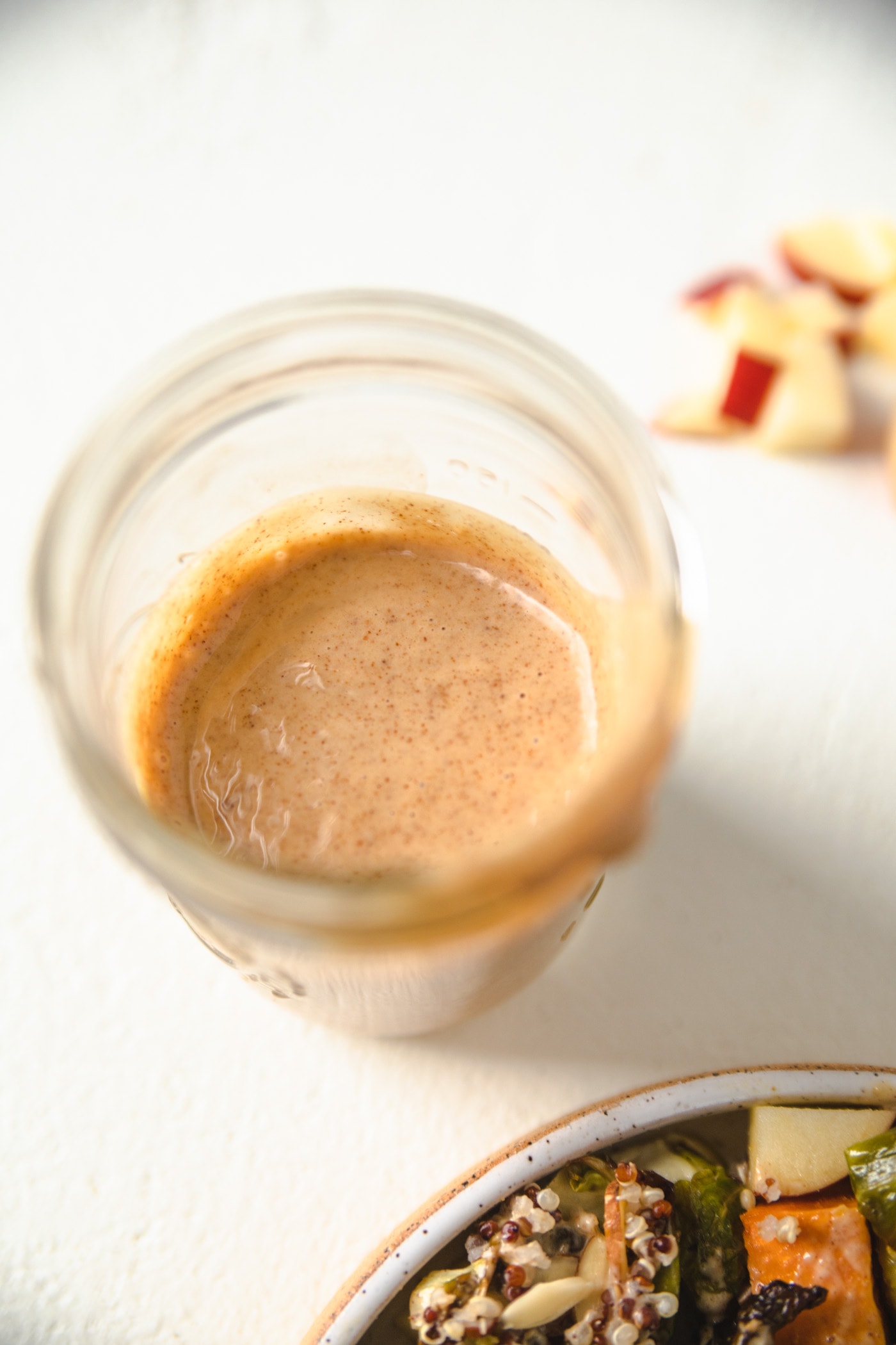 A mason jar filled with almond ginger dressing. 